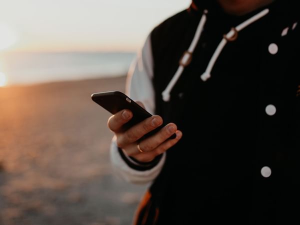 A person on their phone by the beach