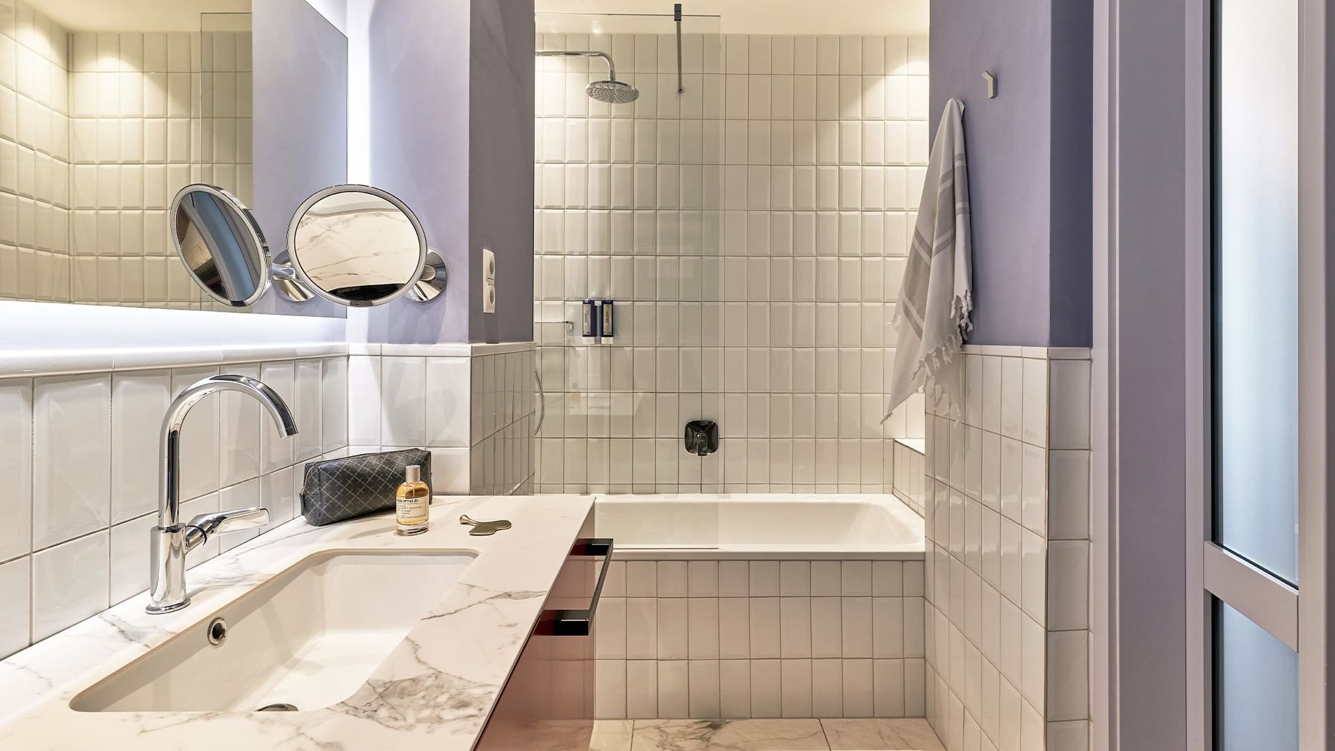 Koupelna Junior Suite s vanou a umyvadlem na mramorové desce v Falkensteiner Hotel Prague v Praze.