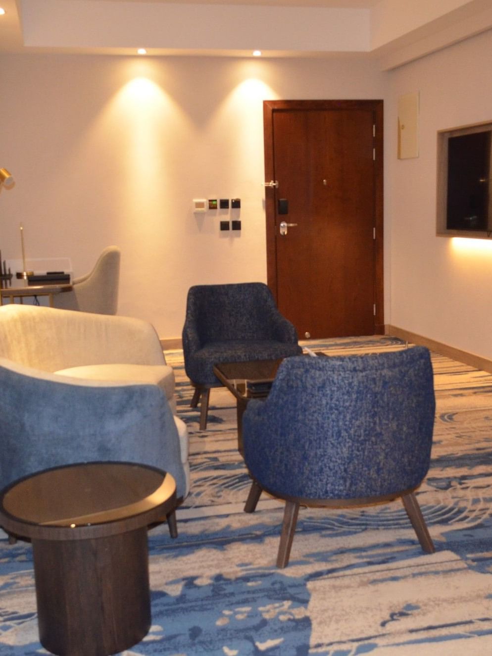TV lounge with plush sofa beside doorway in Junior Suite at Warwick Jeddah Hotel & Spa