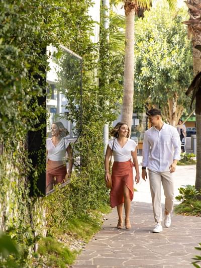 Couple walking on James Street next to a green wall near Sofitel Brisbane Central