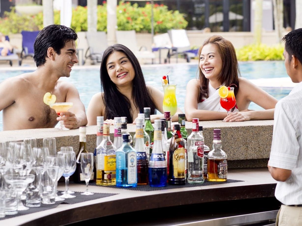 Three people enjoying drinks at the Pool Bar
