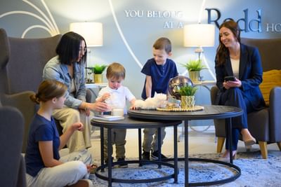 Families relaxing and playing in the cozy lobby of Rodd Moncton, perfect for pet-friendly hotels in Moncton trips