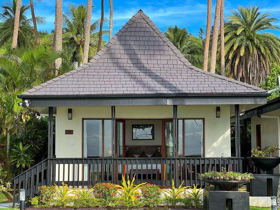 A tropical villa with glass doors and a gray roof at The Naviti Resort Fiji.