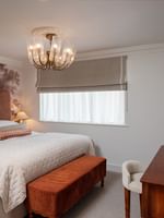 penthouse with a large bed, rustic bench, wooden desk, and wall-mounted TV at The Capital Hotel & Townhouse