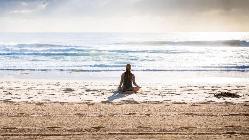 Girl doing Yoga on the beach near Legacy Vacation Resorts