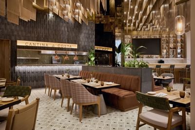 A stylish hotel restaurant lounge featuring an elegant bar counter with contemporary barstools.