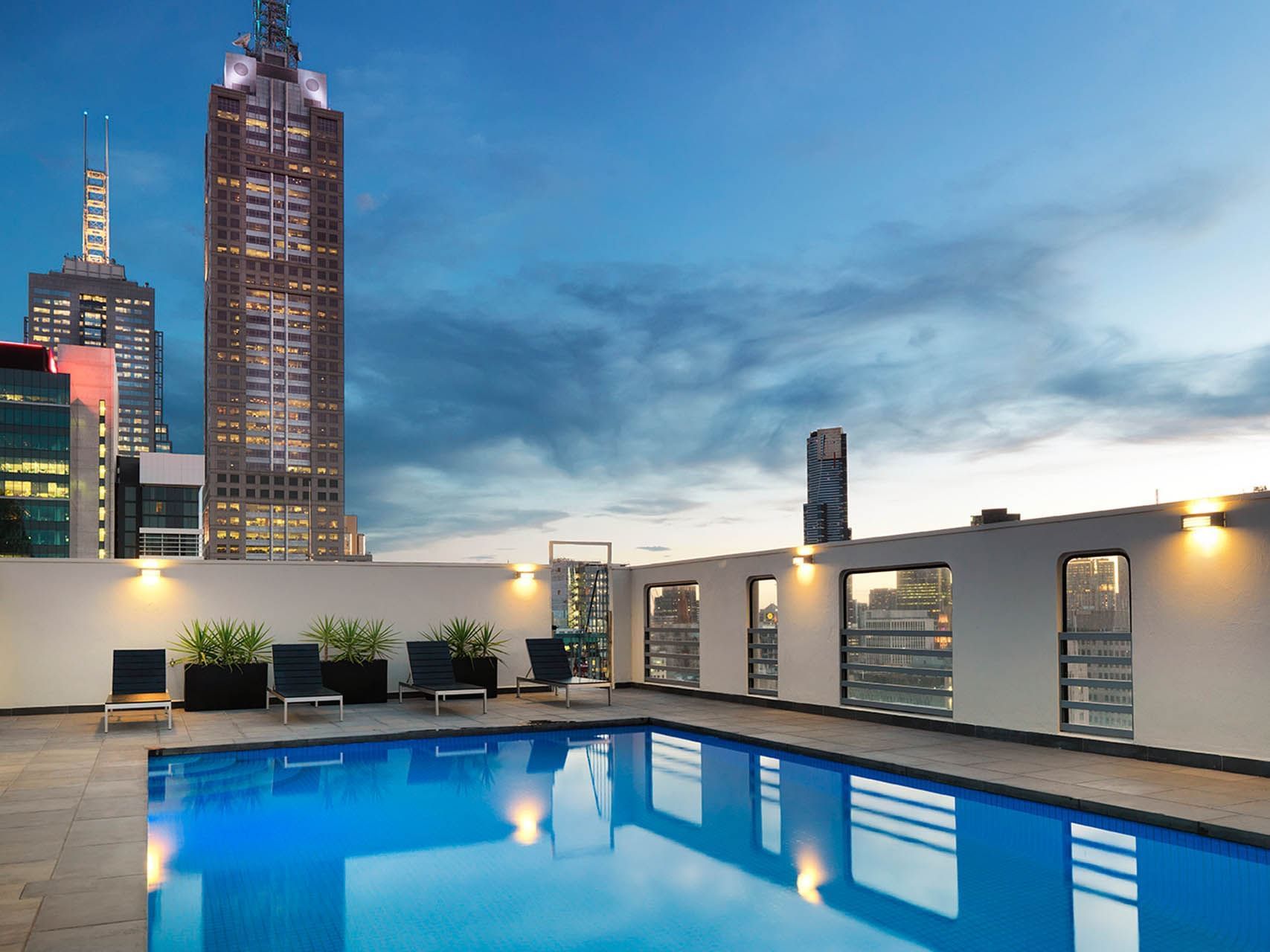 Rooftop swimming pool with sunbeds & a city view at Hotel Grand Chancellor Melbourne