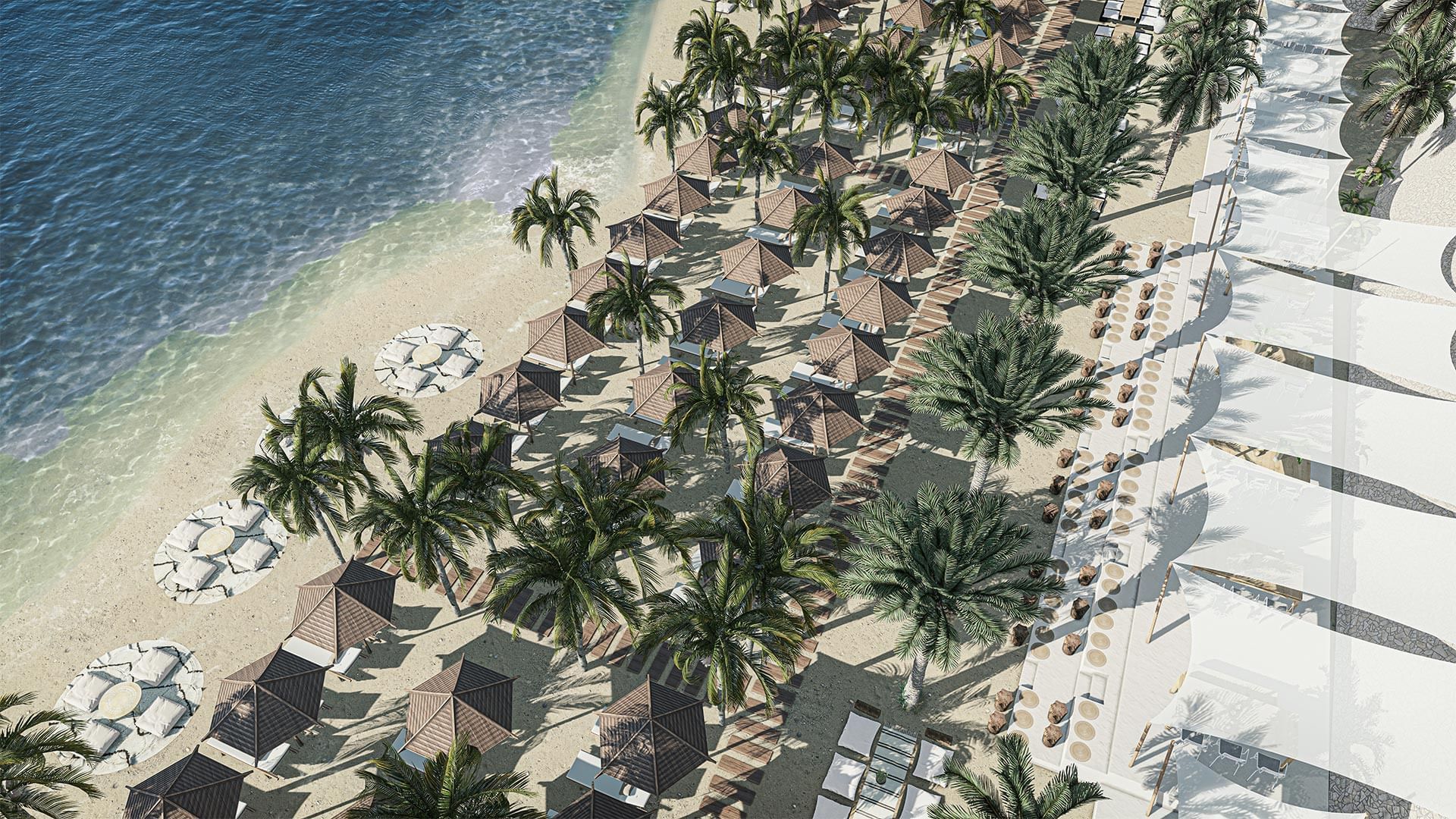 Aerial view of a sandy beach lined with palm trees, palm huts, and lounge chairs at Titanic Deluxe Sharm El Sheikh