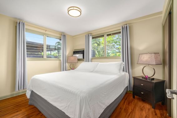 Comfy bed & wooden floors in One-Bedroom Suite Classic at Paradise Bay Resort