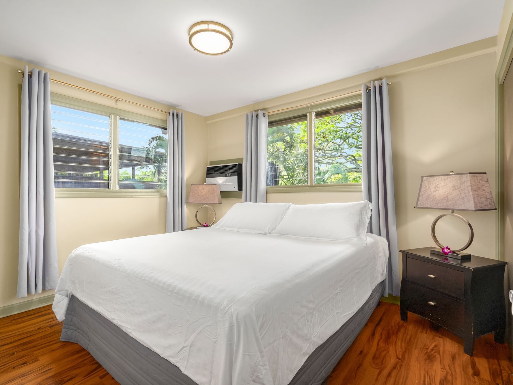 Comfy bed & wooden floors in One-Bedroom Suite Classic at Paradise Bay Resort