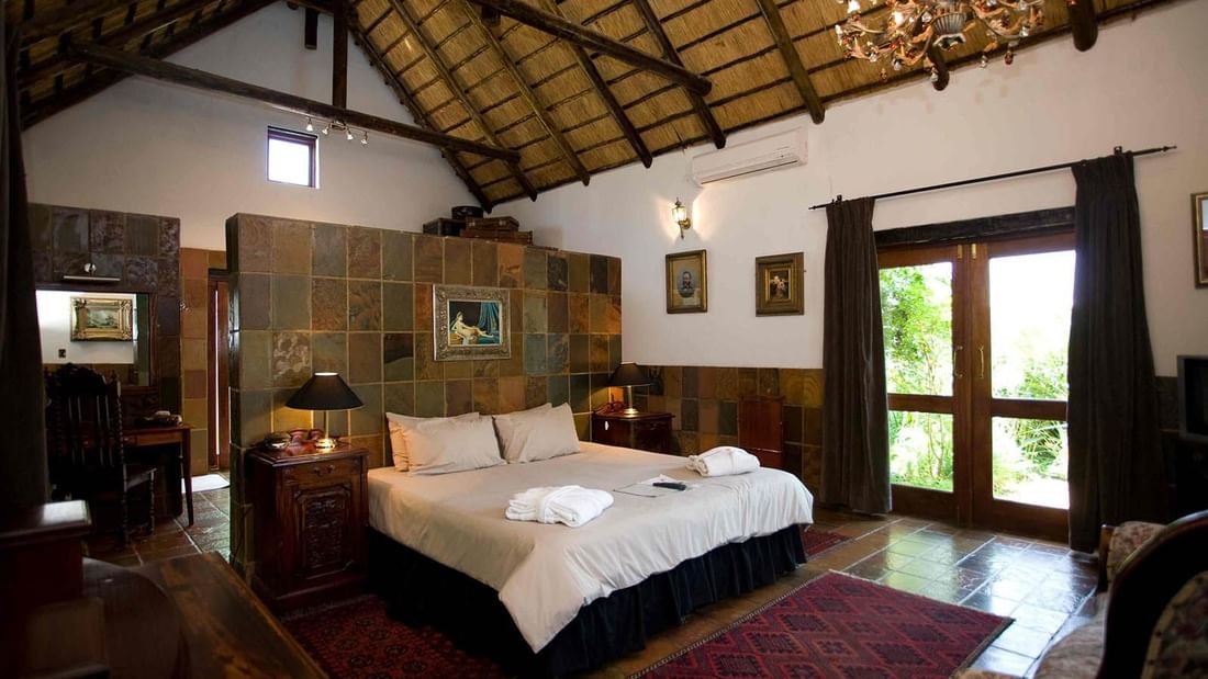 King-size bed with painted portraits in Royal Suite at Kedar Heritage Lodge, Conference Centre & Spa