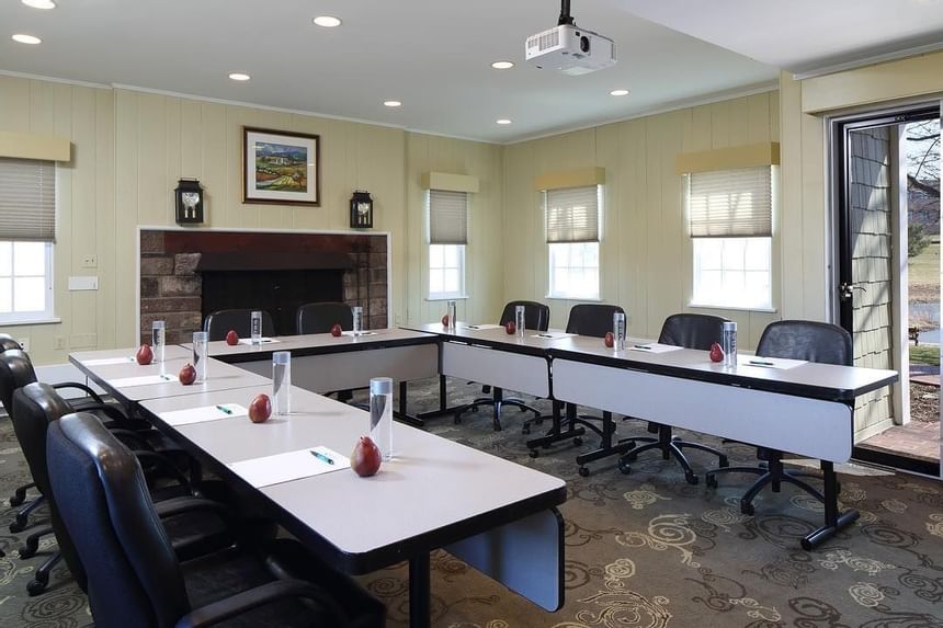 Conference room with classroom-style seating, ceiling-mounted projector, and fireplace at Aramark Chauncey Conference Center