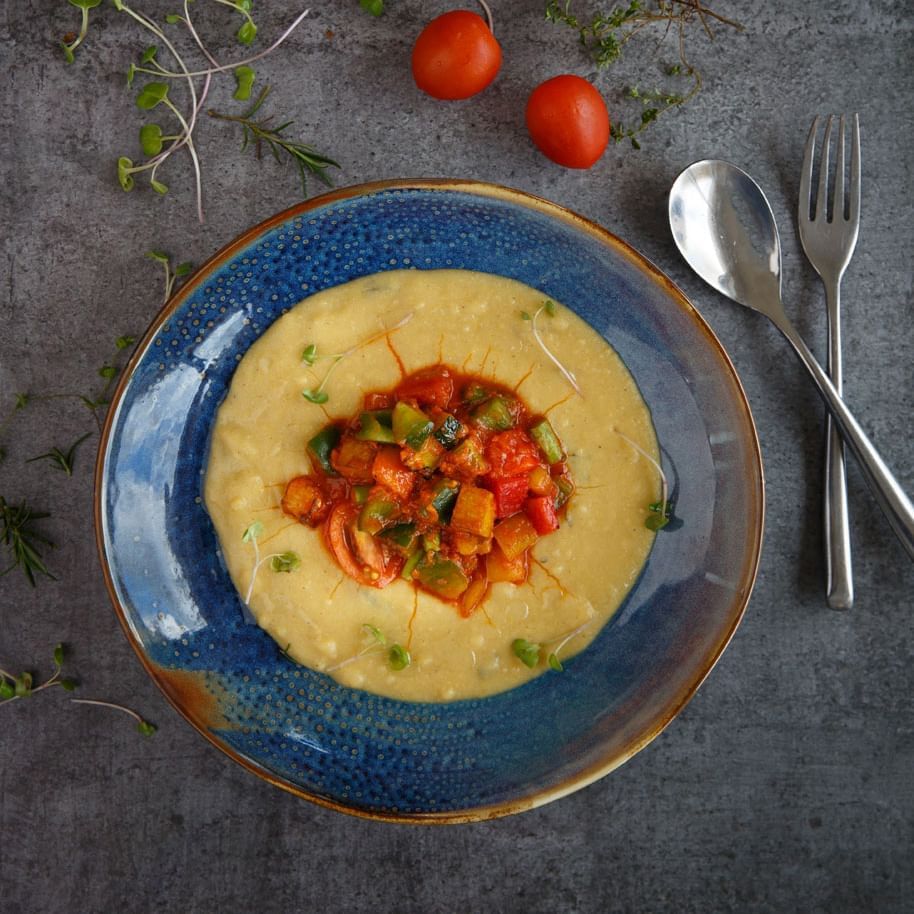 A bowl of creamy polenta with tomatoes served in Elevate at The Terraces Resort & Spa