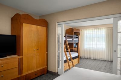 Wooden ladder by bed in the guest room at Anaheim Portofino Inn, an Anaheim hotel with bunk bed kids rooms near Disneyland