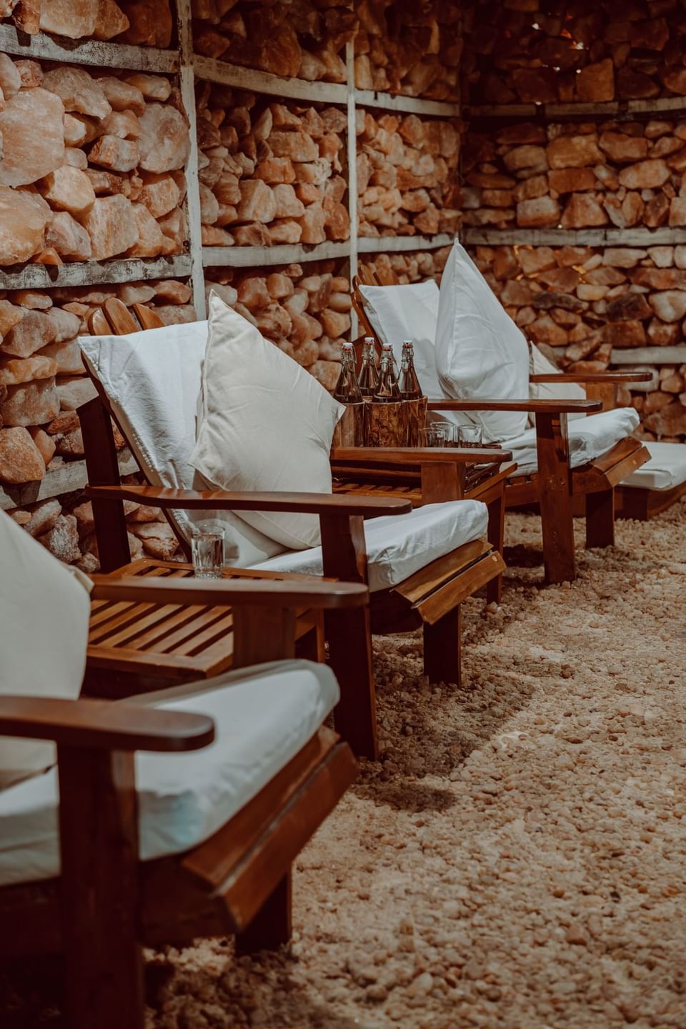 Cozy Himalayan Salt House with wooden lounge chairs and a salt rock wall at The Dwarika's Himalayan Wellbeing