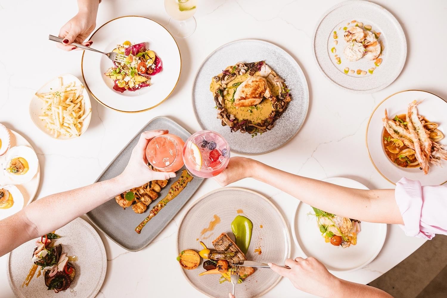 Bistro Manly at Elysium Hotels offers a seafood-focused menu and cocktails on a white marble table