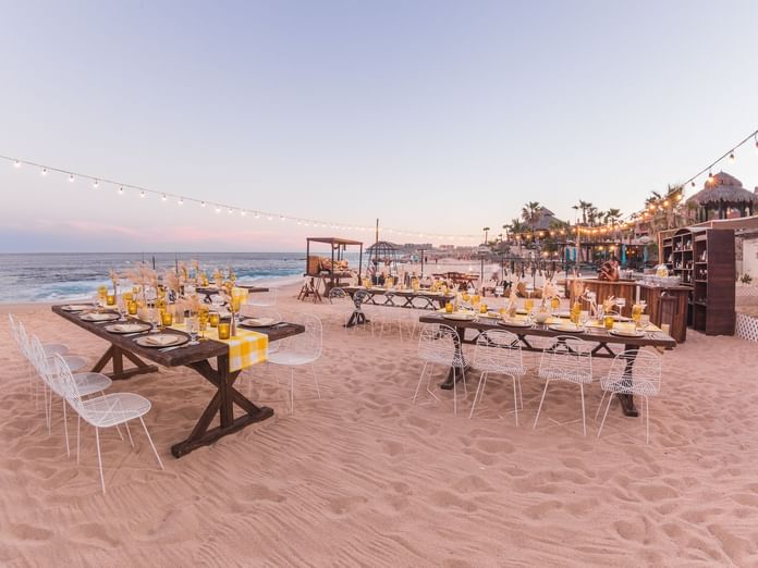 BBQ Dinner arrangements on the beach with chairs and candles at Montage - Hacienda del Mar Los Cabos