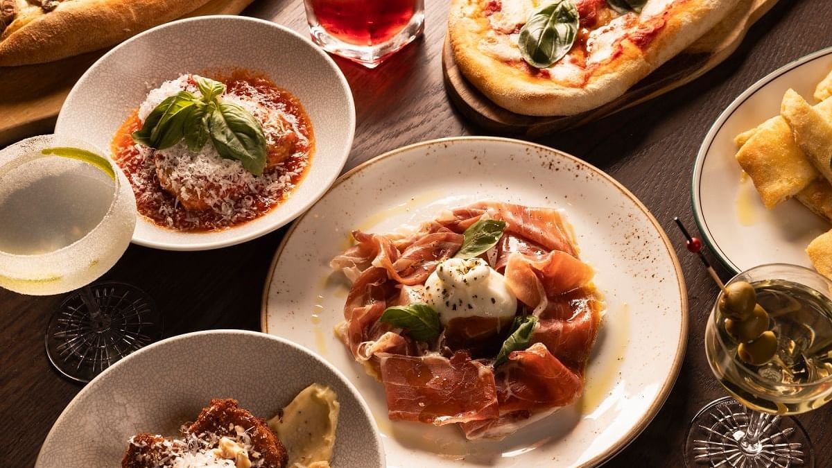 Italian dishes on a table including pizza, pasta and prosciutto served in Di Francesco Cucina at Crown Hotel Melbourne