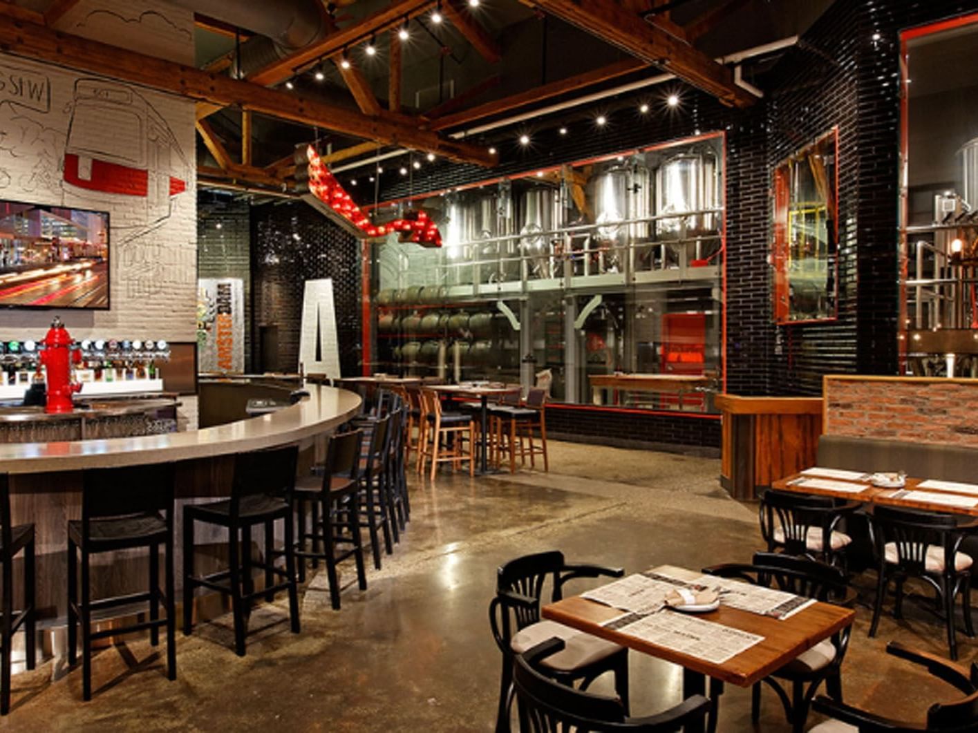 Amsterdam Brewhouse with bar stools, dining tables, and brewing equipment near Hotel X Toronto
