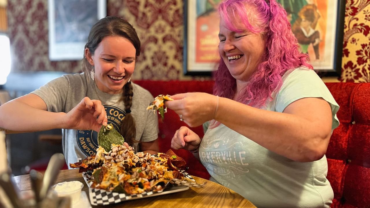 Two people eating nachos