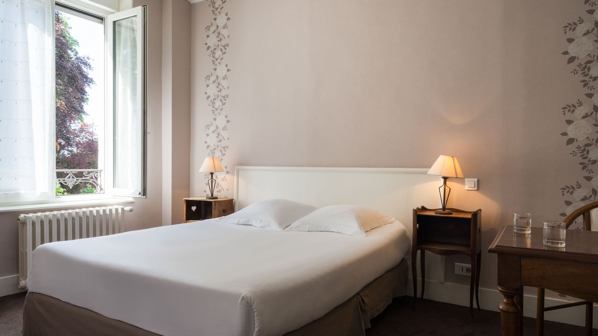 Double bed & bedside tables with lamps at Originals Hotels