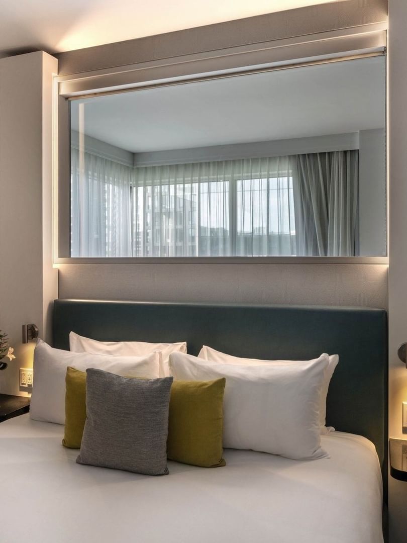 Une suite junior avec un grand lit et vue sur la ville au Warwick Le Crystal Montréal.