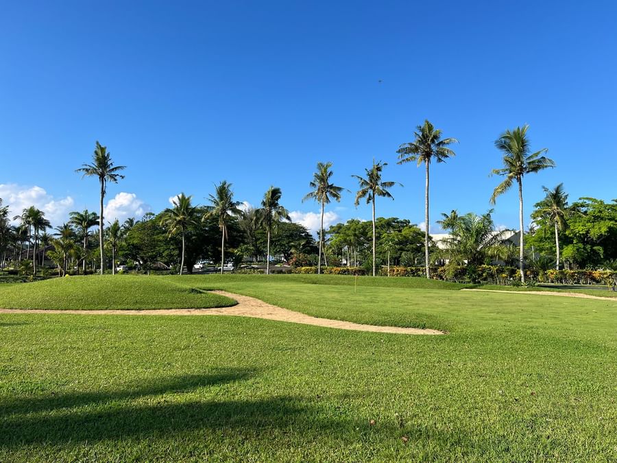 Golf course with lush green grass and palm trees at Warwick Le Lagon - Vanuatu.