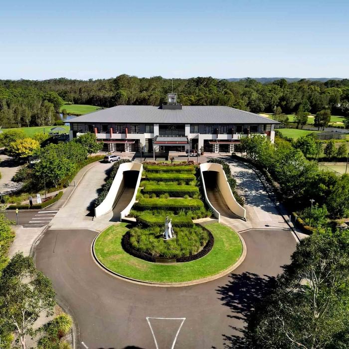 Aerial view of Mercure Kooindah Waters with symmetrical staircases and a circular driveway amidst greenery