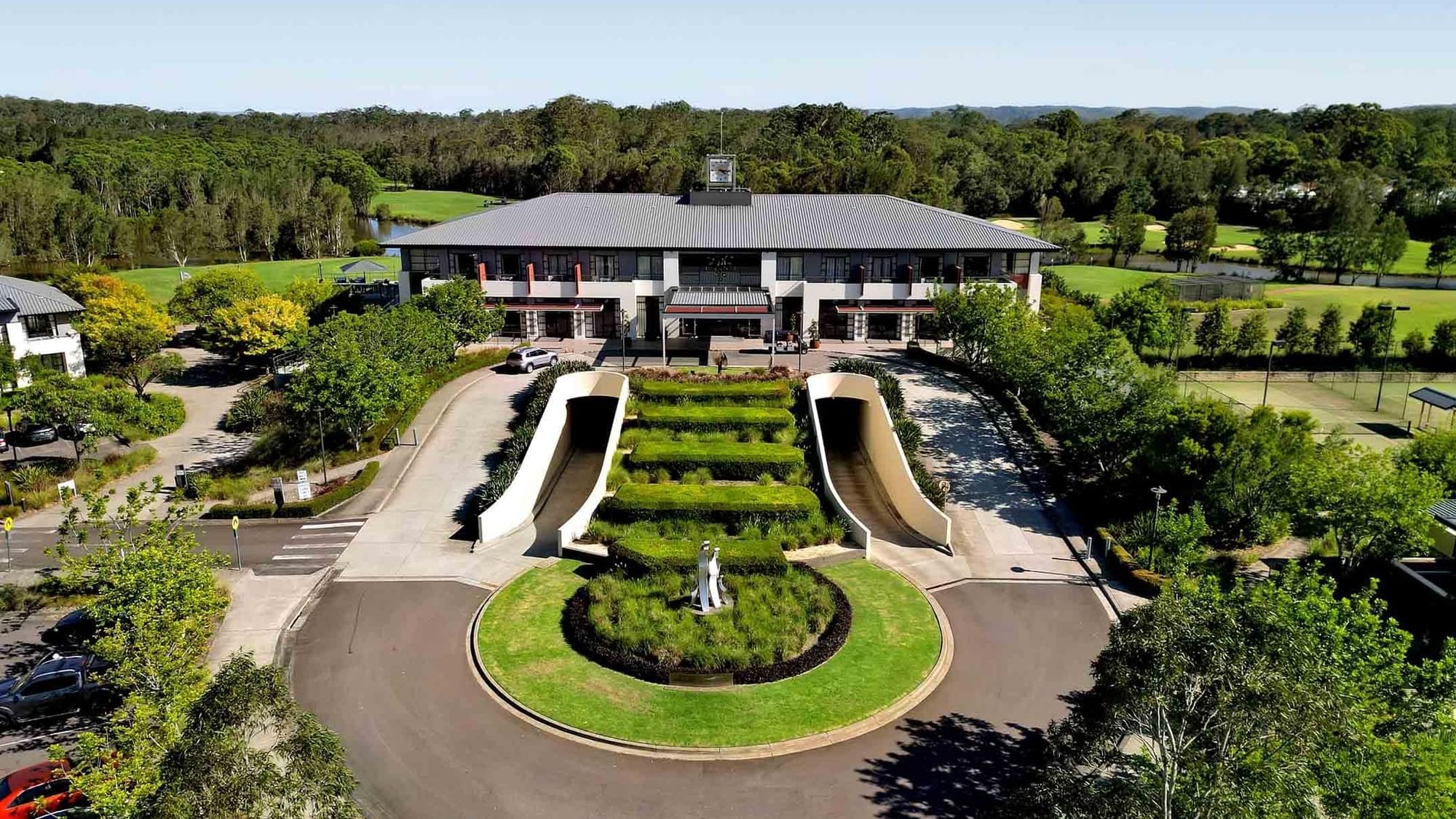 Aerial view of Mercure Kooindah Waters with symmetrical staircases and a circular driveway amidst greenery