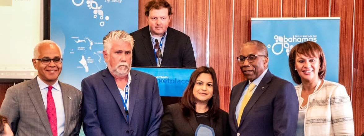 Portrait of hotel staff posing with Traveller's Award at Warwick Paradise Island Bahamas