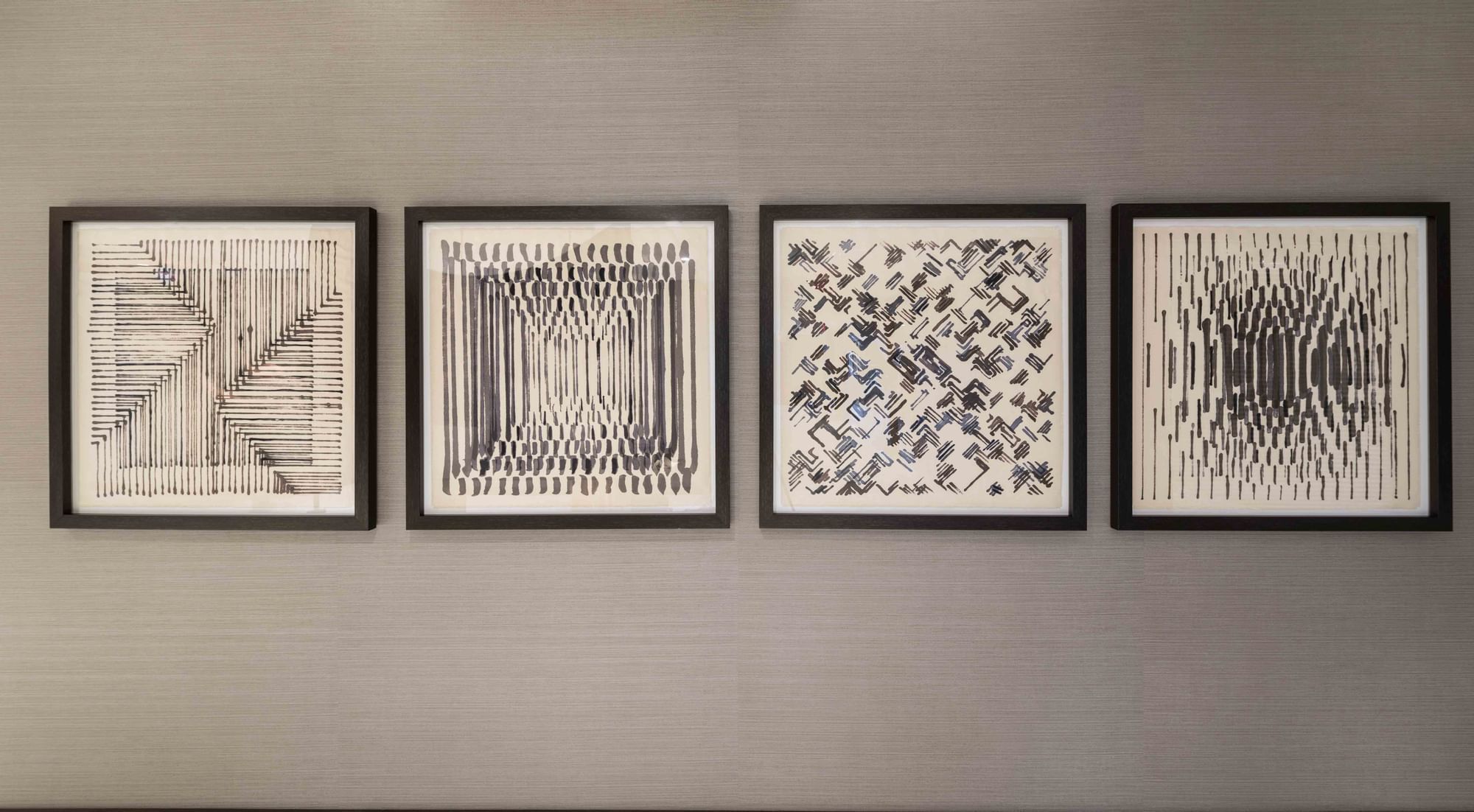Four pieces of geometric abstract art hanging on wall