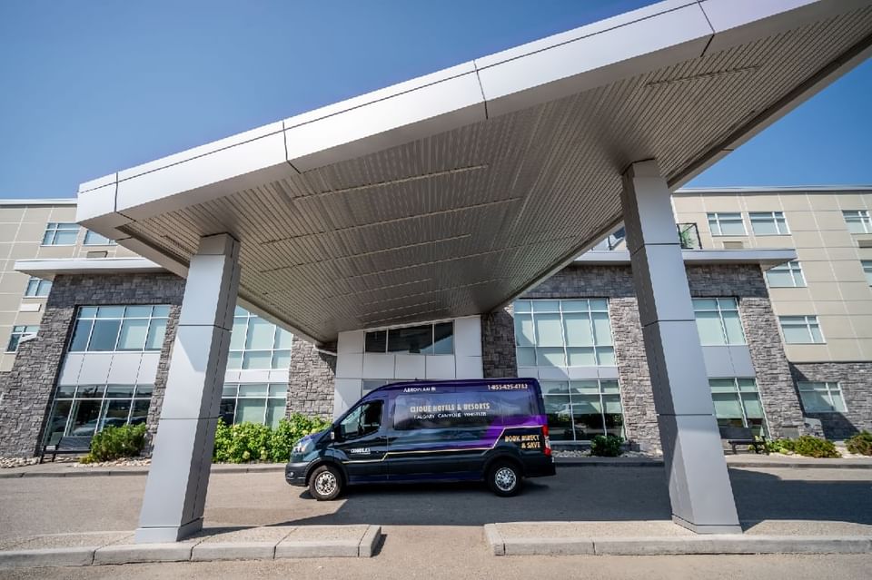 An Airport Shuttle parked in front of Hotel Clique Calgary Airport