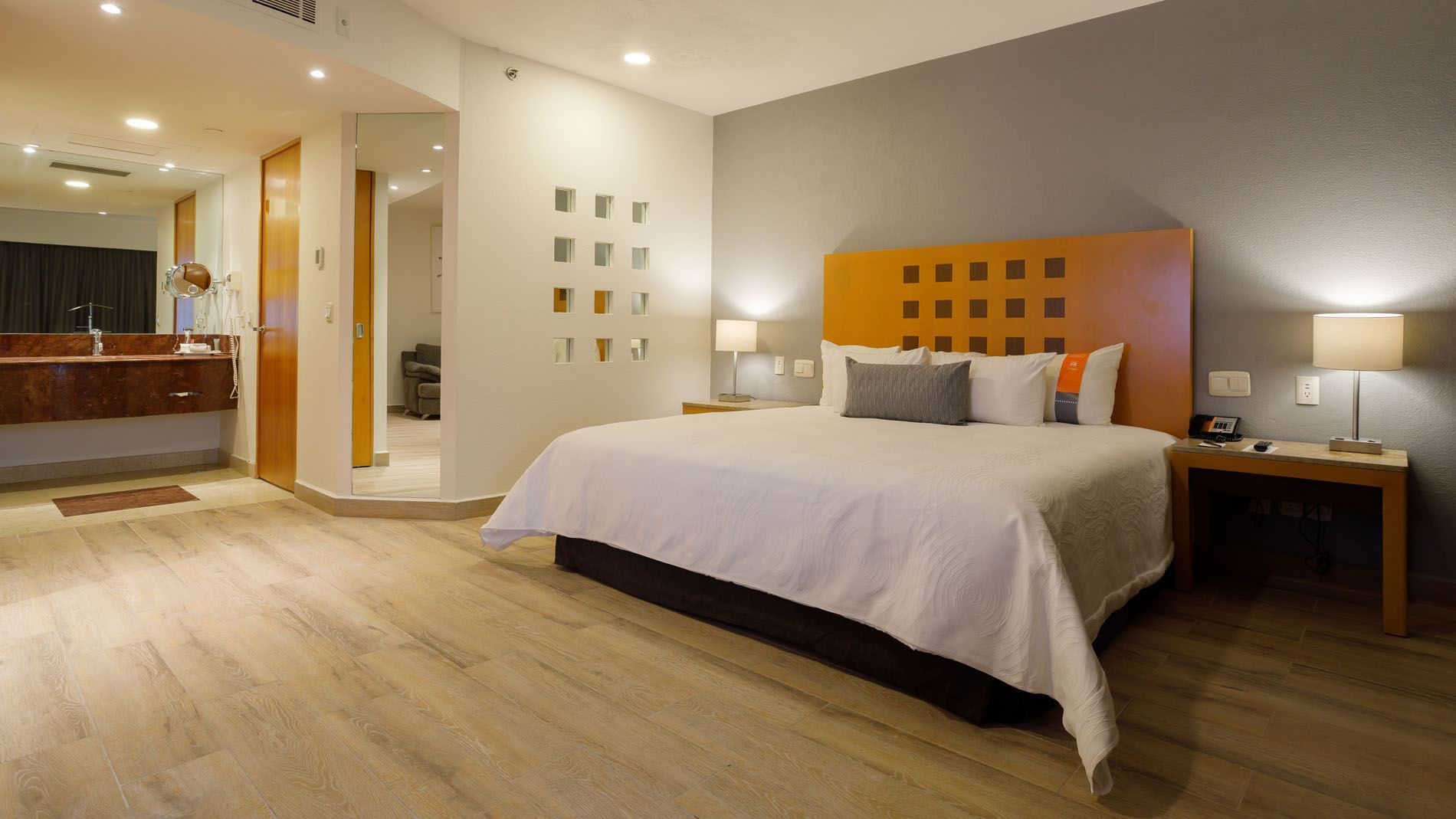 King Master Suite with wood floors, an orange headboard, and a bright, spacious layout at Real Inn Torreon