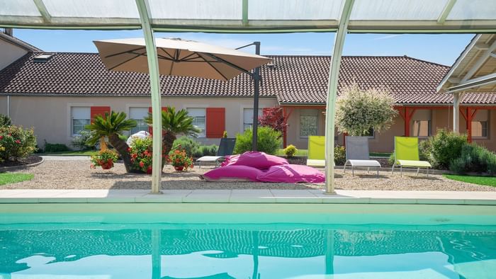 Outdoor swimming pool with pool beds at Hotel le pillebois