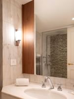 Moderne badkamer met marmeren wastafel en glazen douchecabine in een Classic Kamer bij Warwick Brussels Grand-Place