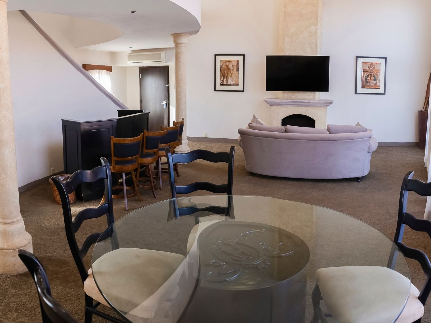 Spacious King Presidential Suite with stone columns, curved sofa, dining area, and flat-screen TV at Quinta Real Zacatecas