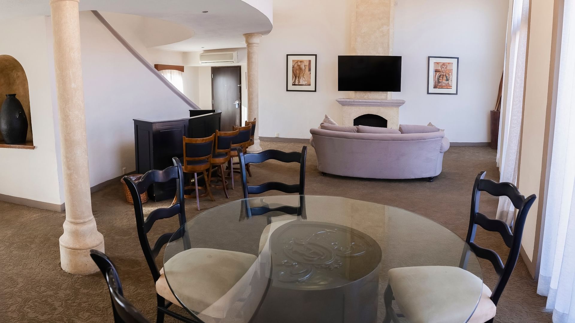 Spacious King Presidential Suite with stone columns, curved sofa, dining area, and flat-screen TV at Quinta Real Zacatecas