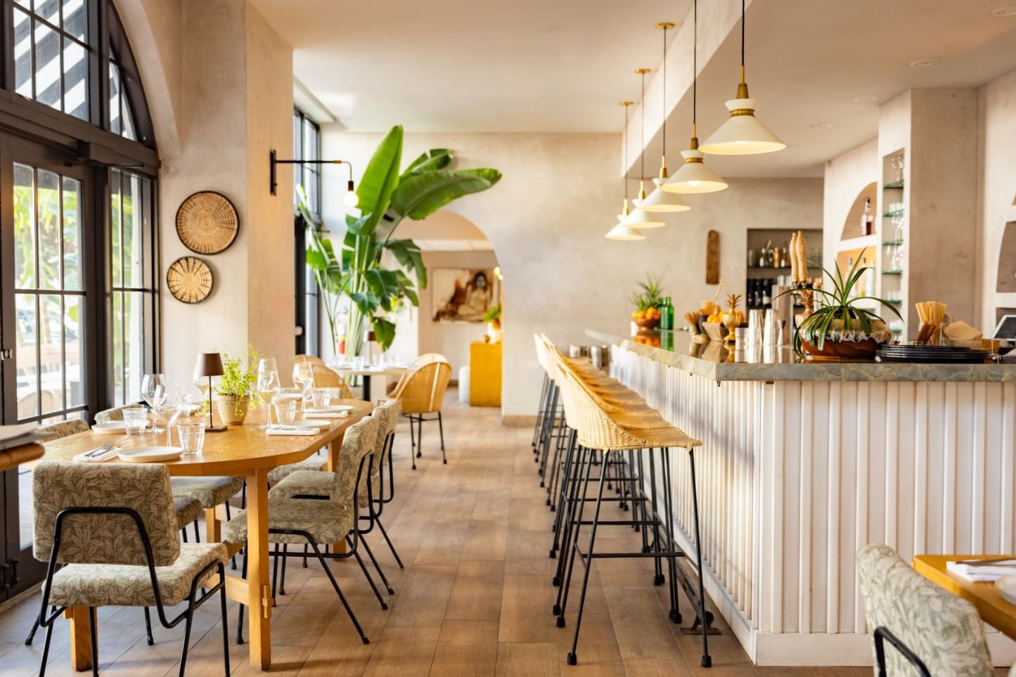 A brightly lit dining area with a bar, tables, and chairs.