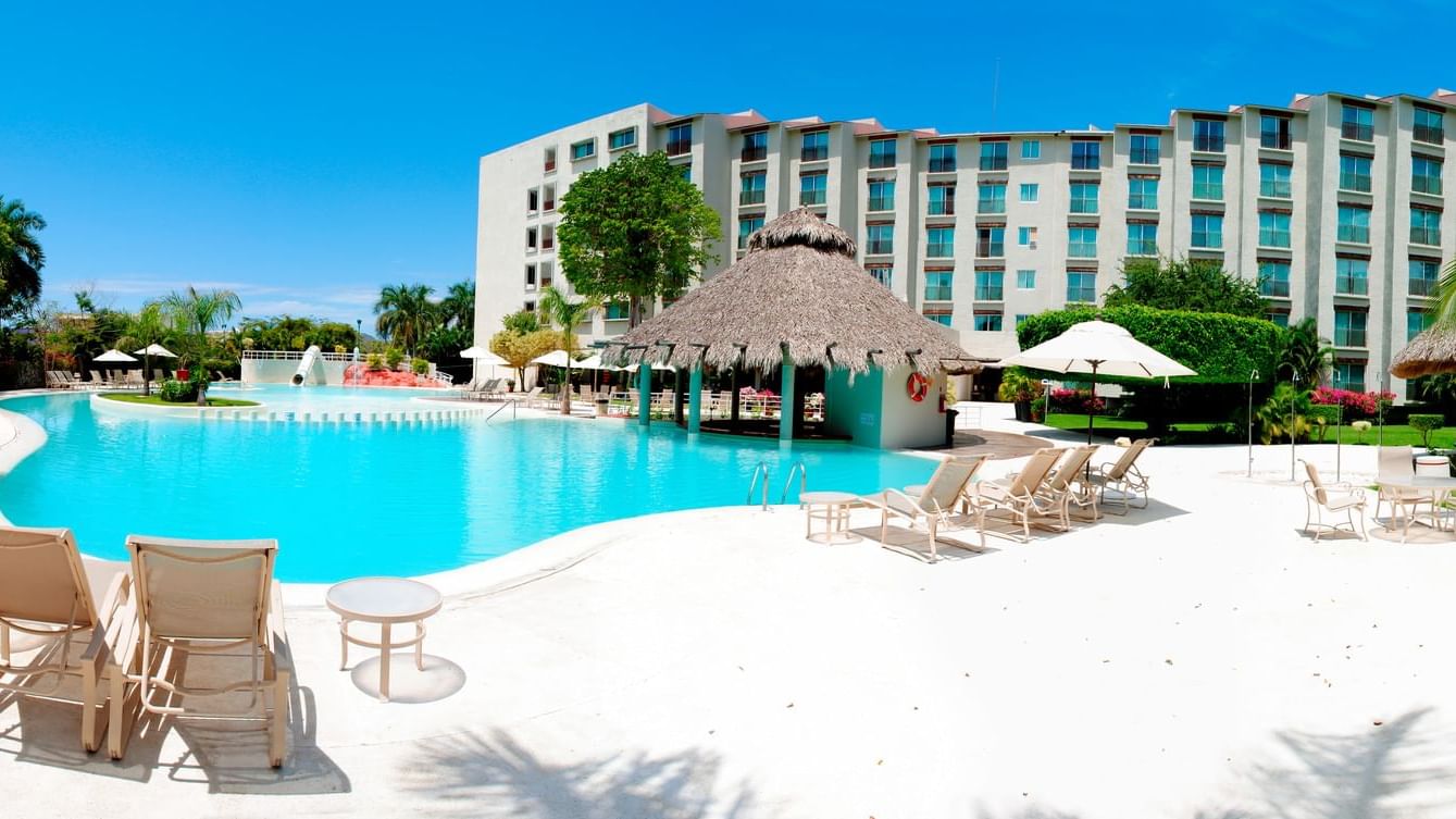 Outdoor pool with sun lounges at Gamma Plaza Ixtapa