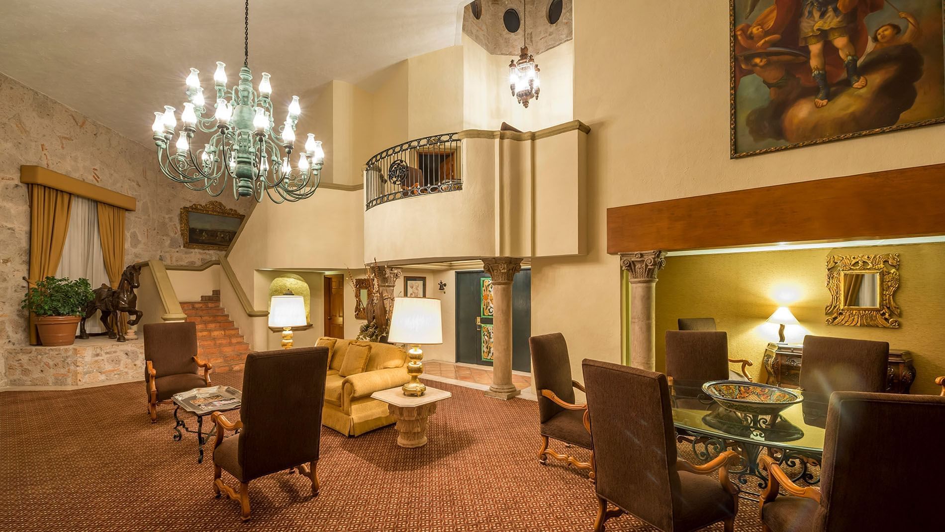 King Presidential Suite lobby with a massive chandelier, stone stairs, and plush seating at Quinta Real Aguascalientes