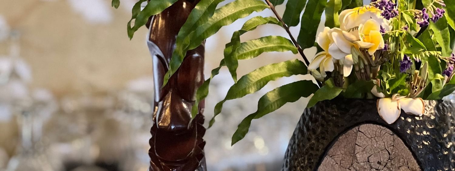 Tropical flower arrangement with wooden figure at Wild Ginger Restaurant & Bar, Efate
