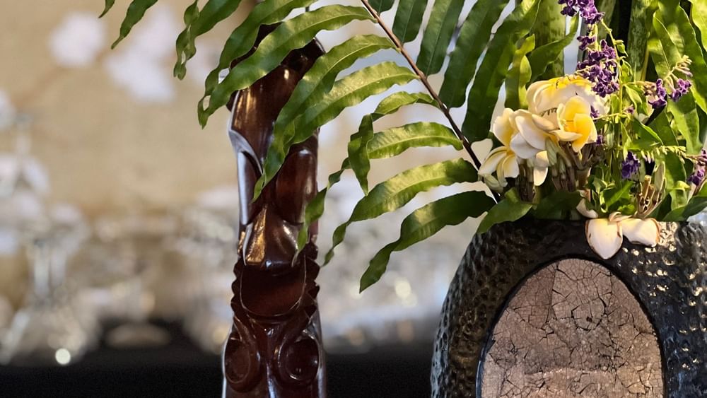 Tropical flower arrangement with wooden figure at Wild Ginger Restaurant & Bar, Efate.