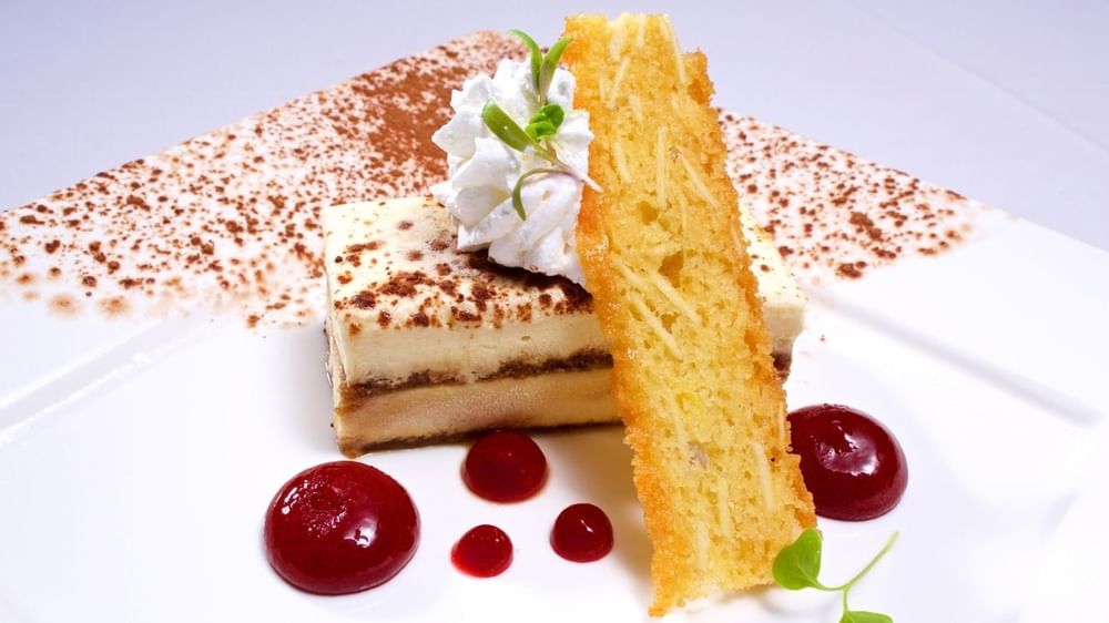 Layered cake with fruit coulis under a chocolate-dusted surface in Abbiocco  at Warwick Paradise Island Bahamas 