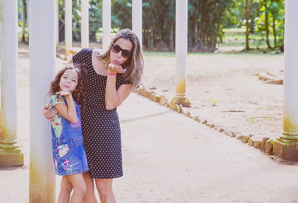 mother and small daughter blowing kisses