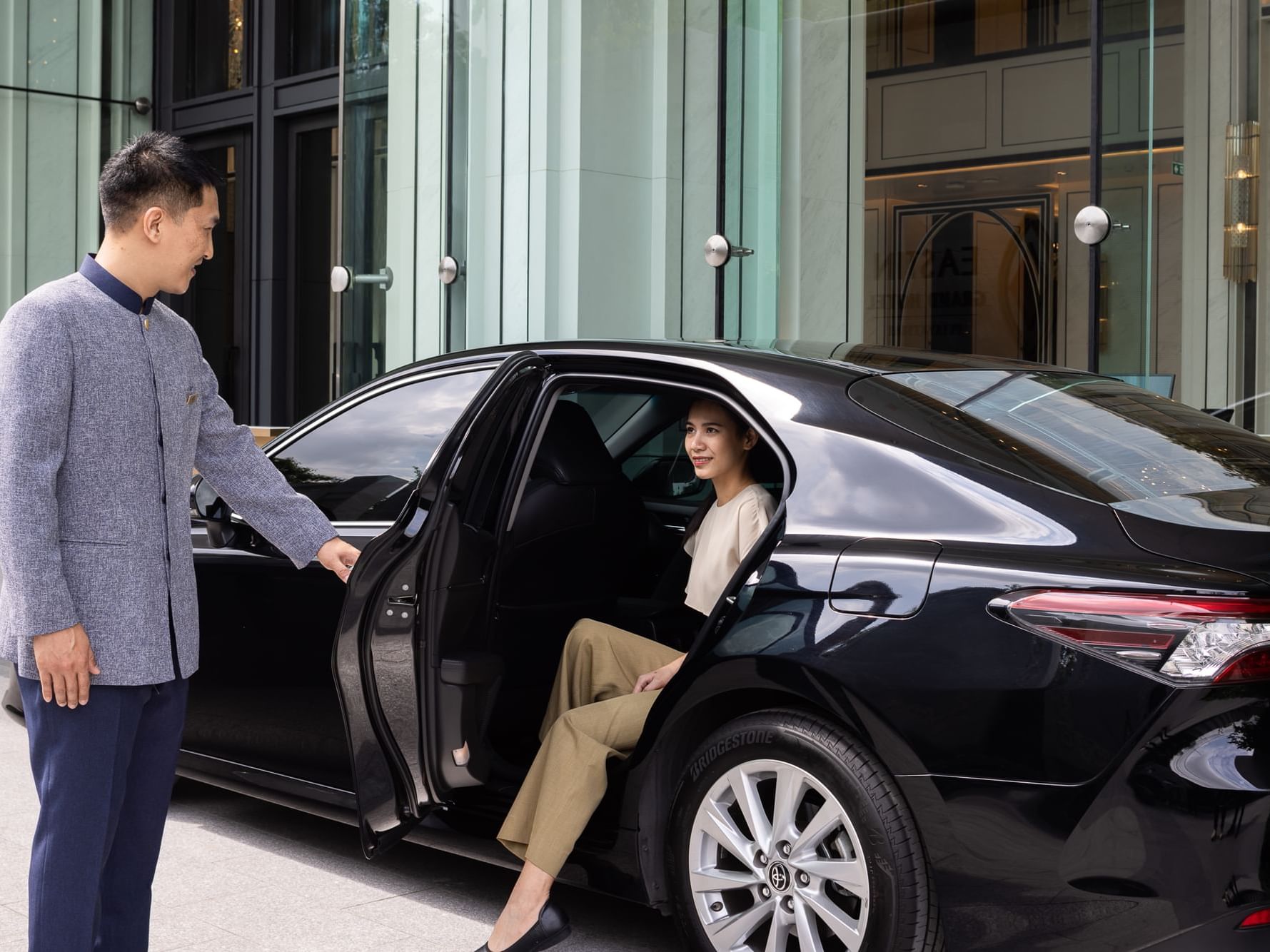 Chauffeur opening the car door for a lady at Eastin Grand Hotel Phayathai