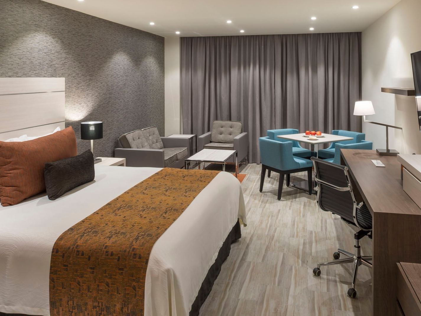 King Superior room featuring a plush king bed, a dining nook, and a spacious wooden work desk at Real Inn Celaya