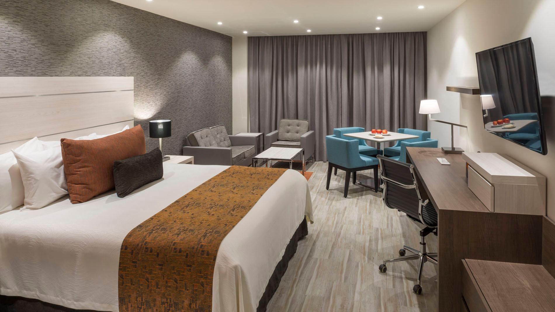 King Superior room featuring a plush king bed, a dining nook, and a spacious wooden work desk at Real Inn Celaya