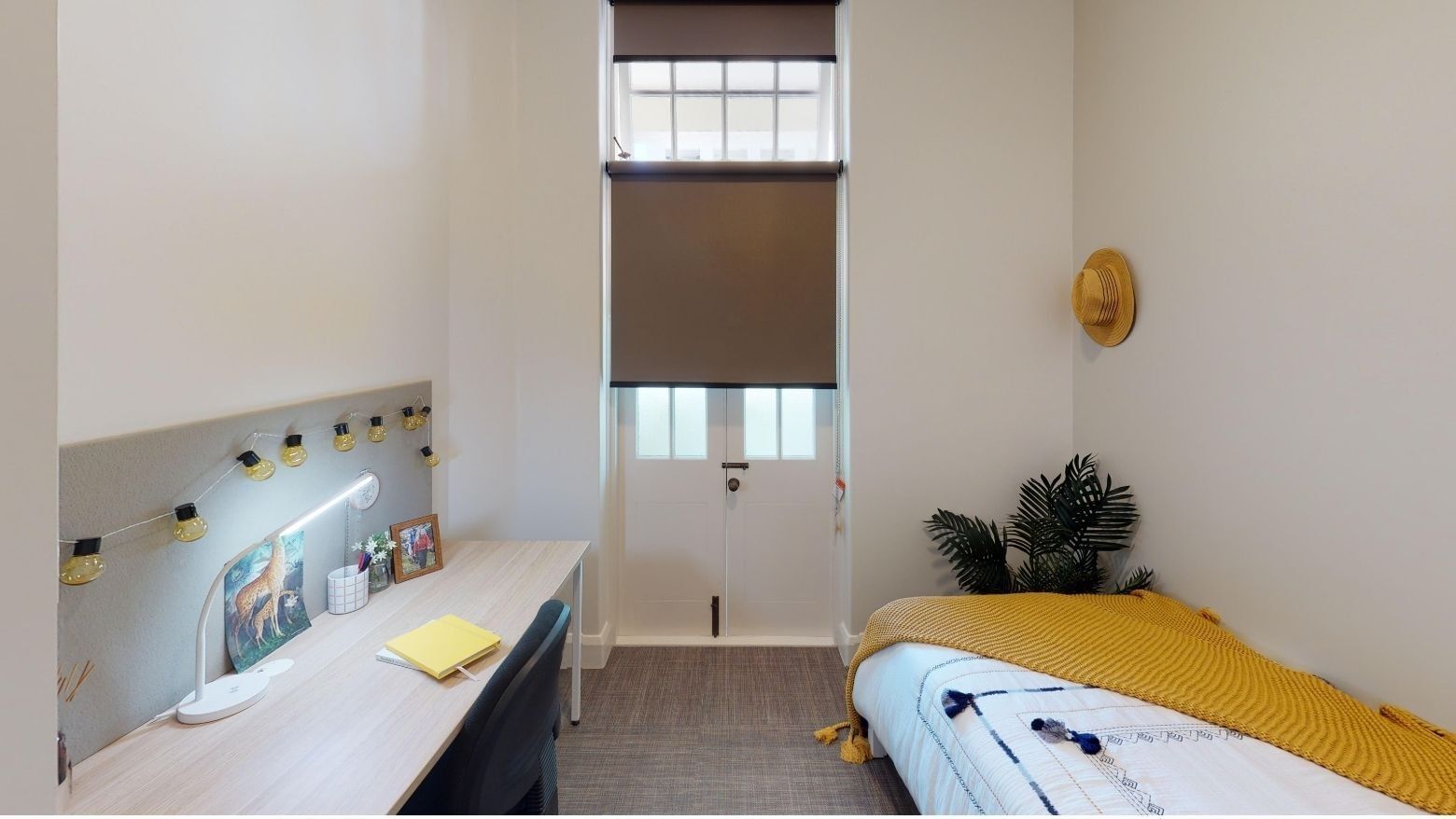 Single Room desk, bed and balcony at UniLodge Herston.