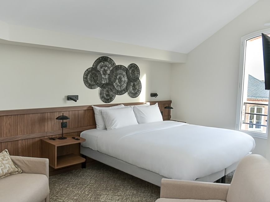 Chambre confortable avec lit blanc et décoration moderne à l'Hôtel Rivella.