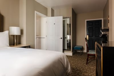 Deluxe Queen Room with a cozy bed, nightstand, and a bathroom door at Hotel Bijou, featuring San Francisco accommodation
